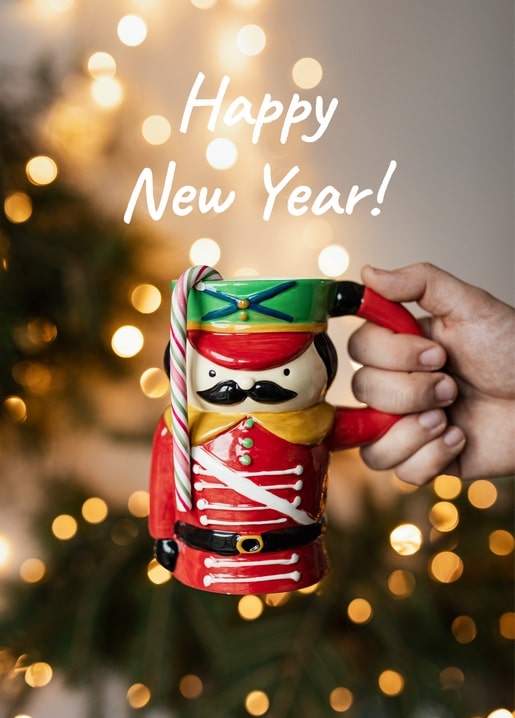 Hand holding a nutcracker-shaped mug with a candy cane and bokeh Christmas lights