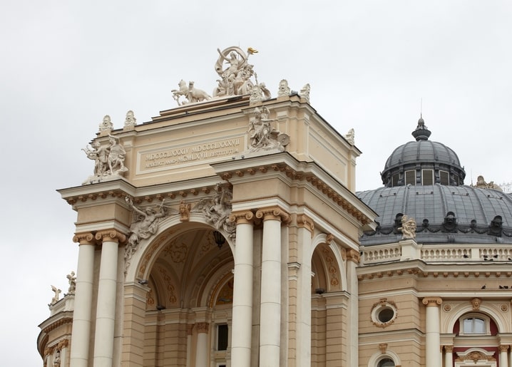 Close-up of the Odesa Opera House façade with columns, gilded chariot sculpture, and copper dome