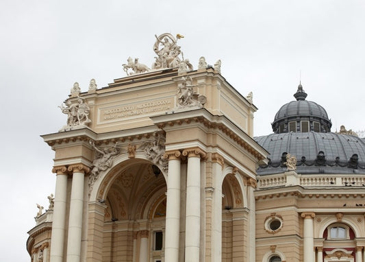 Close-up of the Odesa Opera House façade with columns, gilded chariot sculpture, and copper dome