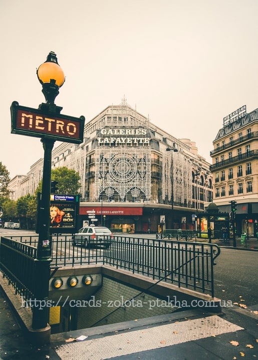 Paris Metro sign and lamppost before the Galeries Lafayette façade
