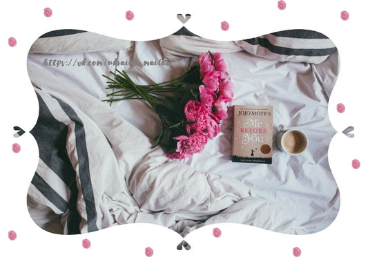 Rosa Pfingstrosen, ein Taschenbuch und eine Tasse Kaffee auf gestreifter Bettwäsche