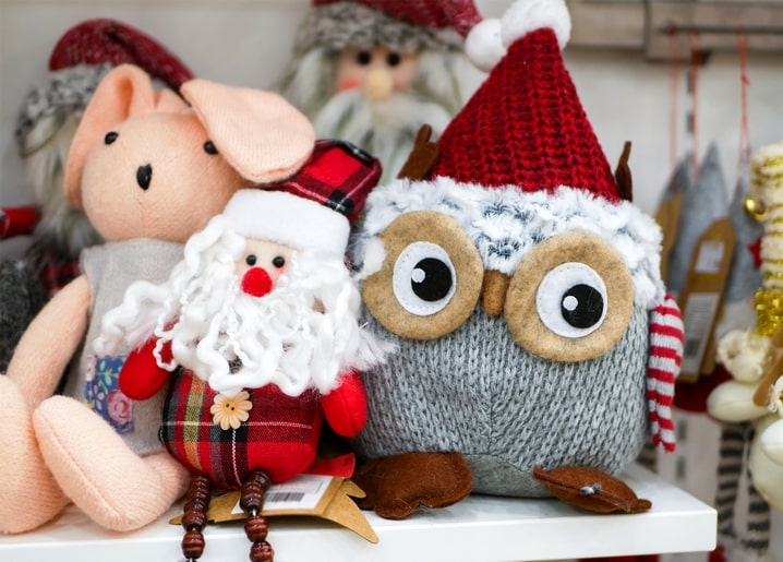 Felt Santa Claus, knitted owl in a red hat, and pink plush bunny on a shelf