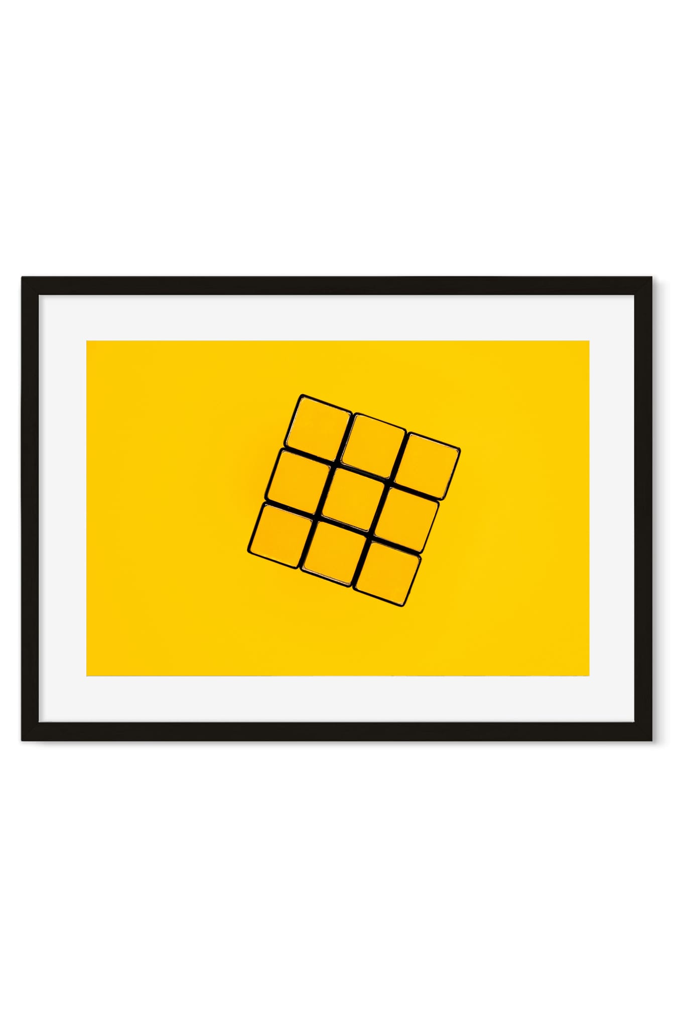 Puzzle cube tilted at an angle on a solid yellow background