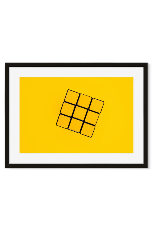 Puzzle cube tilted at an angle on a solid yellow background