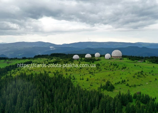 Row of white geodesic radar domes on a green Carpathian ridge at Verkhniy Yalovets