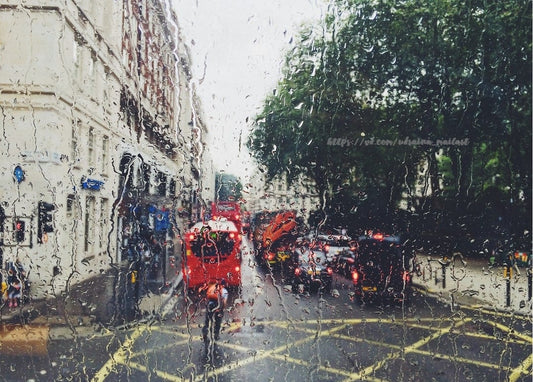 Blick durch ein regennasses Autofenster auf einen roten Bus und Verkehr in London