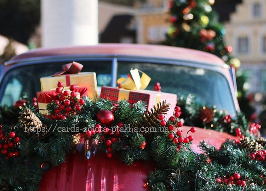 Roter Oldtimer mit Tannengirlande und Weihnachtsgeschenken