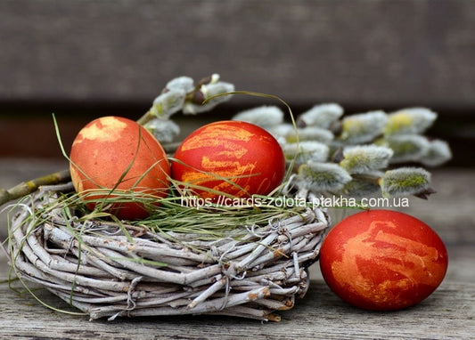 Marbled red dyed eggs in a twig nest with pussy willow branches and grass