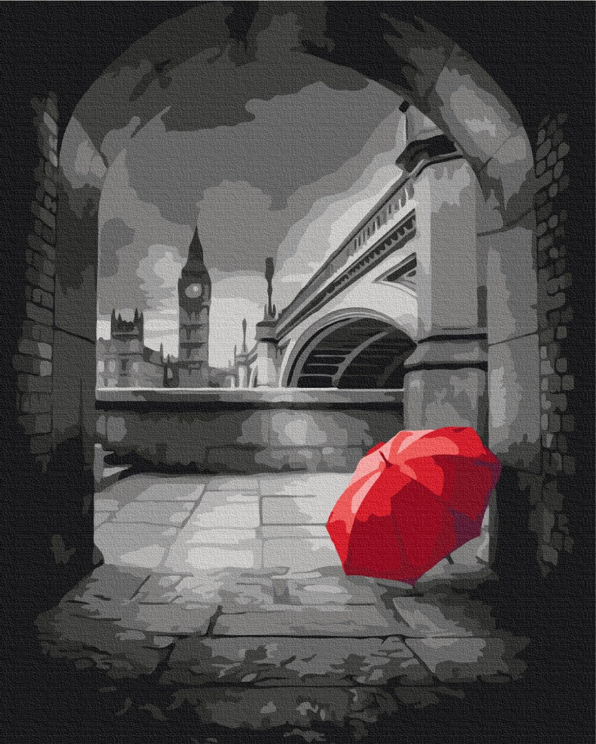 Black-and-white archway view of Big Ben with a single red umbrella on the ground