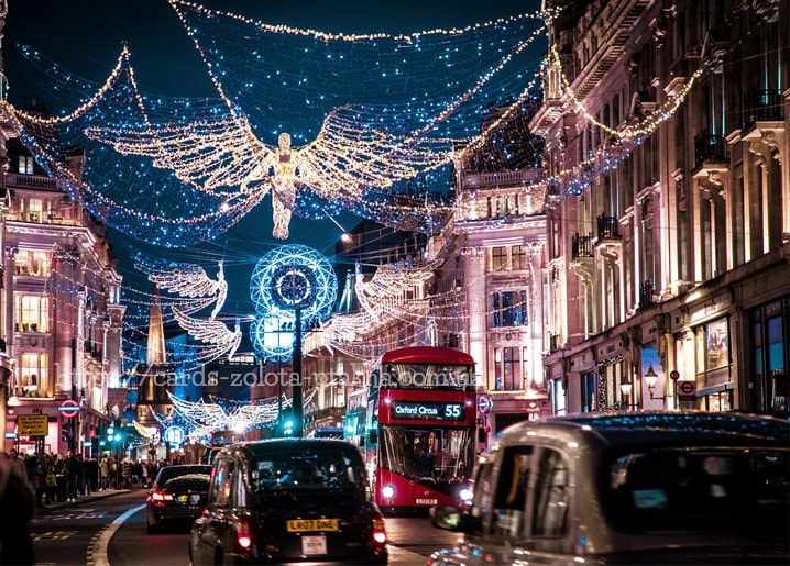 Weihnachtliche Engel-Lichterketten über der Regent Street mit rotem Doppeldeckerbus und Abendverkehr in London