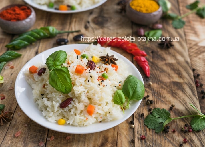 Plate of rice pilaf with basil, star anise and red chili peppers on wood