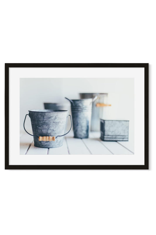 Vintage zinc buckets and pitchers still life on a white wooden table