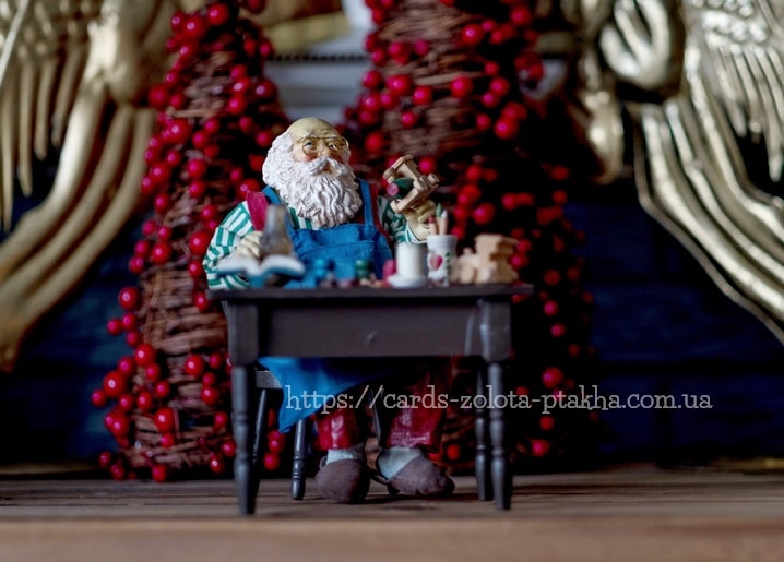 Miniaturfigur des Weihnachtsmanns schnitzt Holzspielzeug an einer Werkbank