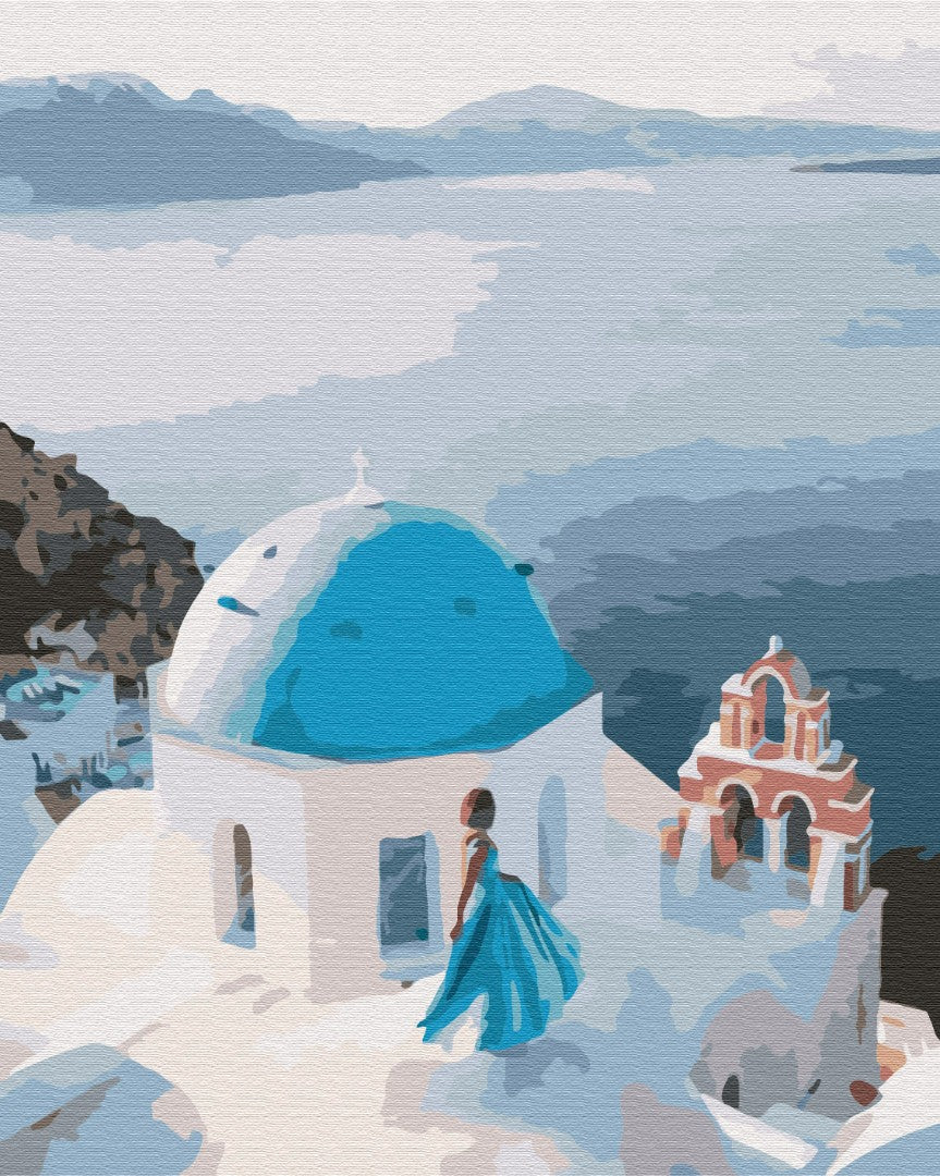 Woman in a blue gown beside a Santorini blue-domed church overlooking the Aegean Sea
