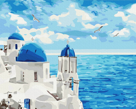 Deep-blue church domes over the Aegean Sea with gulls flying above Santorini's cliffs