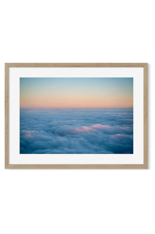 Pink and blue sea of clouds seen from above at sunset