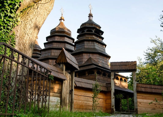 Ярусні дерев'яні бані церкви за різьбленою брамою в Шевченківському гаю у Львові