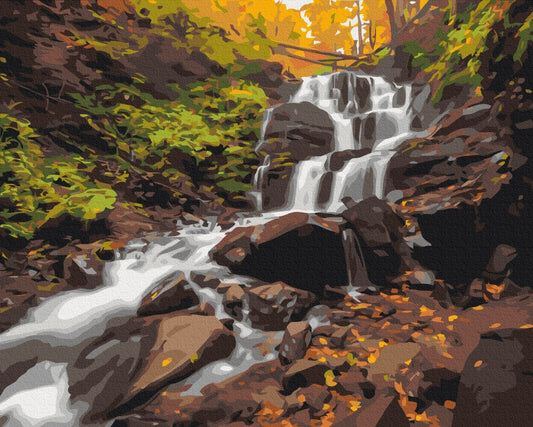 Wasserfall über moosigen Felsen umgeben von goldenem Herbstlaub
