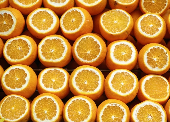 Close-up of rows of oranges sliced in half, showing juicy orange segments and white pith