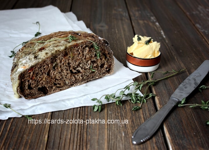 Geschnittenes dunkles Roggenbrot mit Butter und frischem Thymian auf Holztisch
