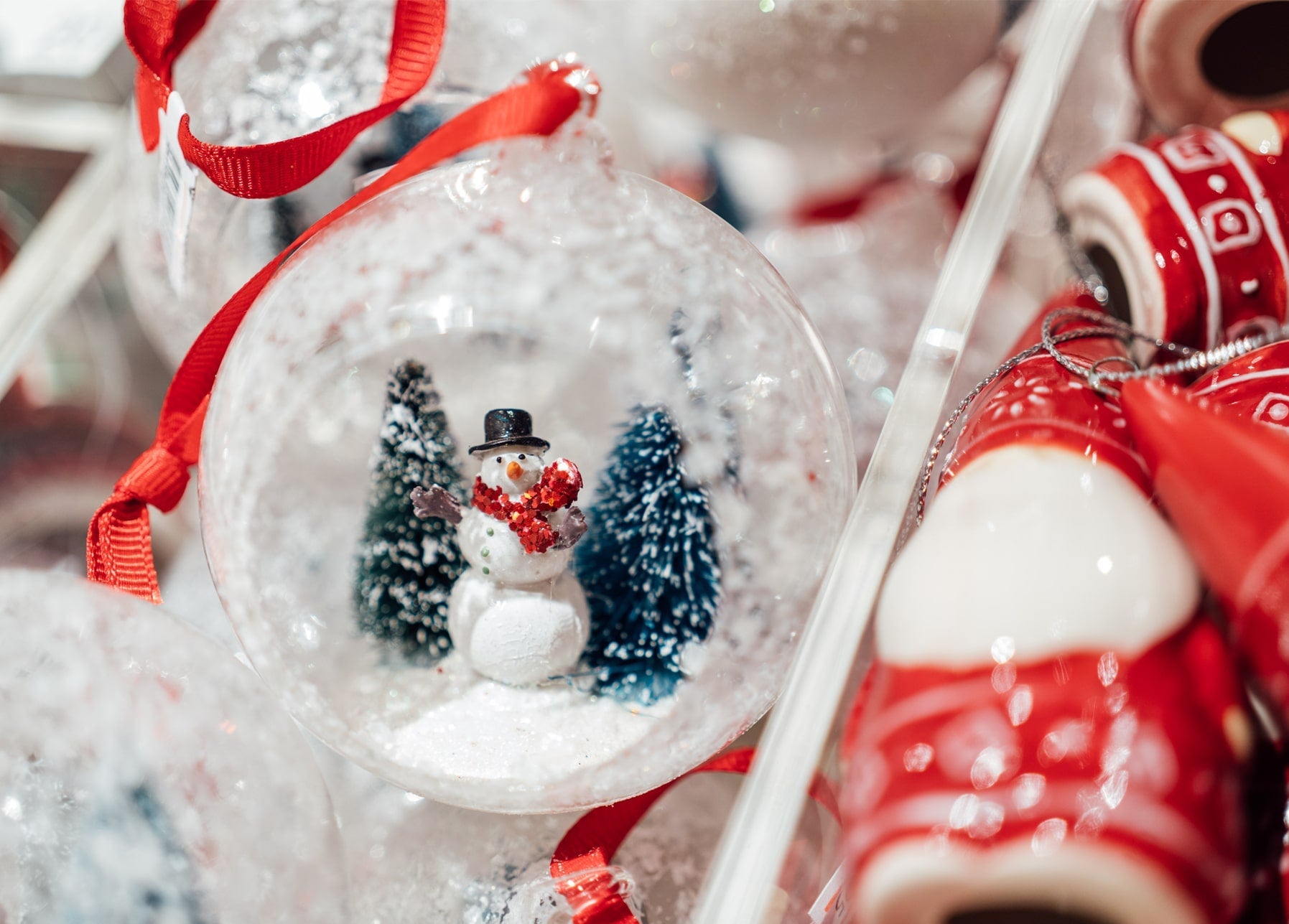 Glaskugel-Anhänger mit kleinem Schneemann und Tannen, mit rotem Band