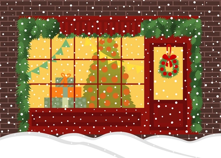Snowy brick storefront with a wreathed door, garlands, and a lit Christmas tree in the window
