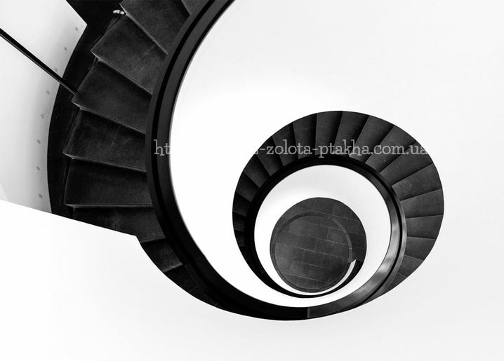 Schwarz-weißes Foto einer Wendeltreppe von direkt oben, die konzentrische Kreise bildet