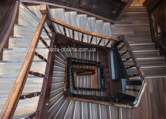 Overhead view of a spiral wooden staircase in an old Lviv building