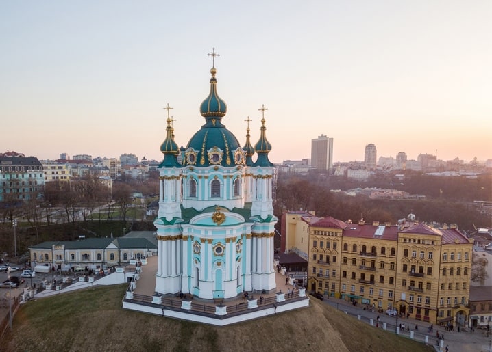 Андріївська церква з бірюзовими банями на заході сонця над Києвом