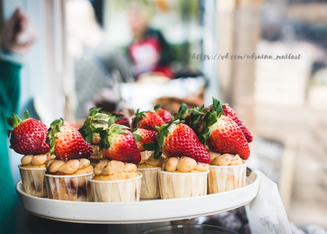 Mini-Cupcakes mit Karamellcreme und frischer Erdbeere auf einem Café-Ständer