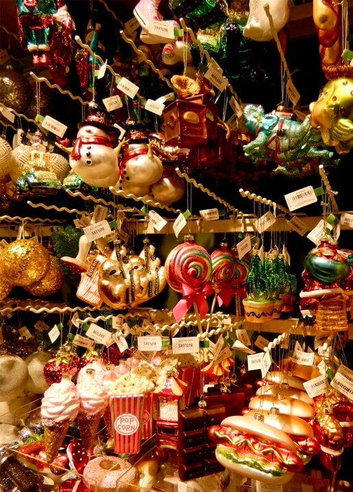 Glasornamente in Form von Schneemännern, Popcorn und Lolli auf einem Weihnachtsmarktstand