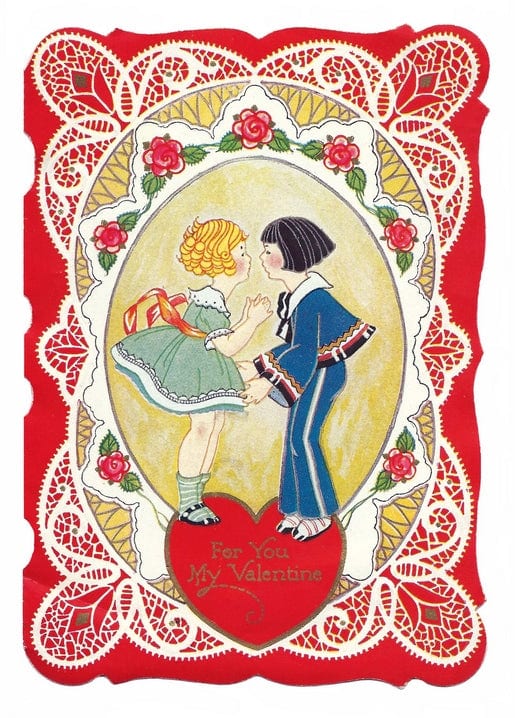 Vintage-Postkarte mit einem Mädchen und einem Jungen in einem Rosen- und Spitzenrahmen auf einem roten Herzen.