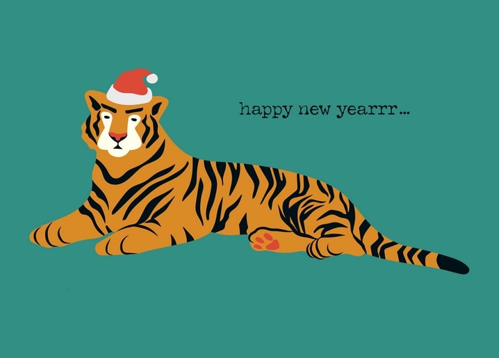 Tiger wearing a Santa hat lying down with a handwritten ‘happy new year’ caption
