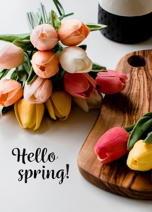 Tulip bouquet on a wooden board with a handwritten Hello Spring greeting