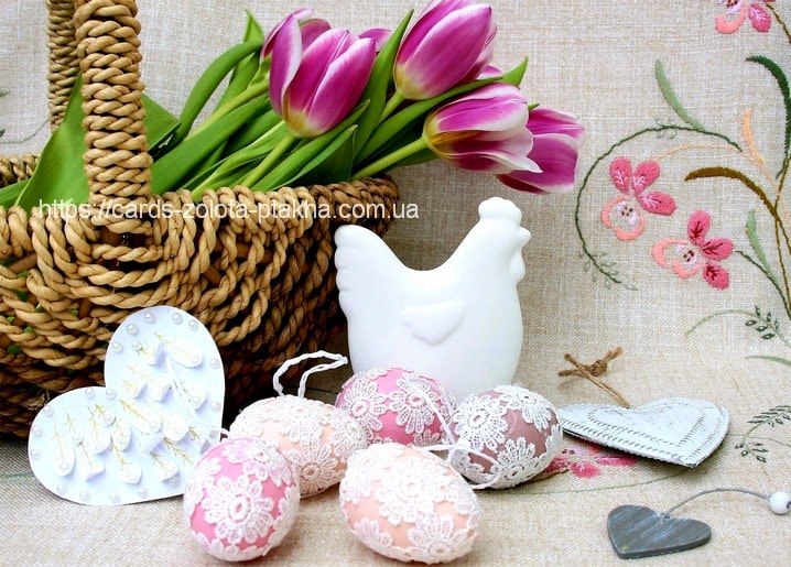Weidenkorb mit Tulpen, Keramikhuhn-Figur und spitzenbesetzten rosa Ostereiern