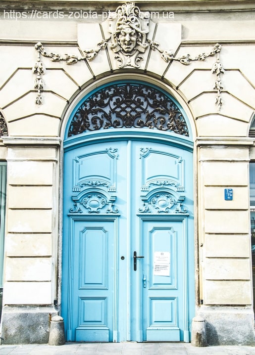 Türkisfarbene Barocktür mit geschnitztem Maskaron und schmiedeeisernem Fenstergitter