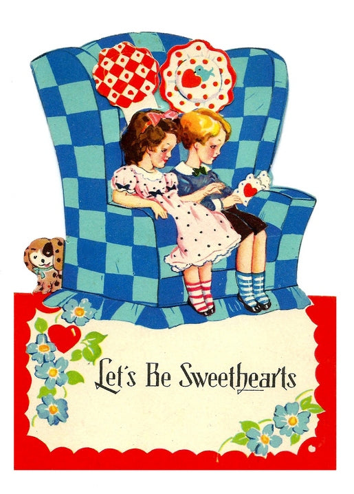 Vintage-Postkarte mit zwei Mädchen in einem blau karierten Sessel mit Herzkissen und einem Welpen.