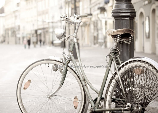 Vintage-Fahrrad mit Ledersattel an einer Laterne auf einer Kopfsteinpflasterstraße