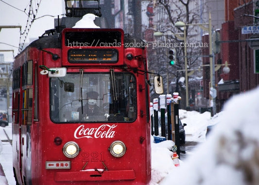 Rote Vintage-Straßenbahn mit Scheinwerfern auf einer verschneiten Straße