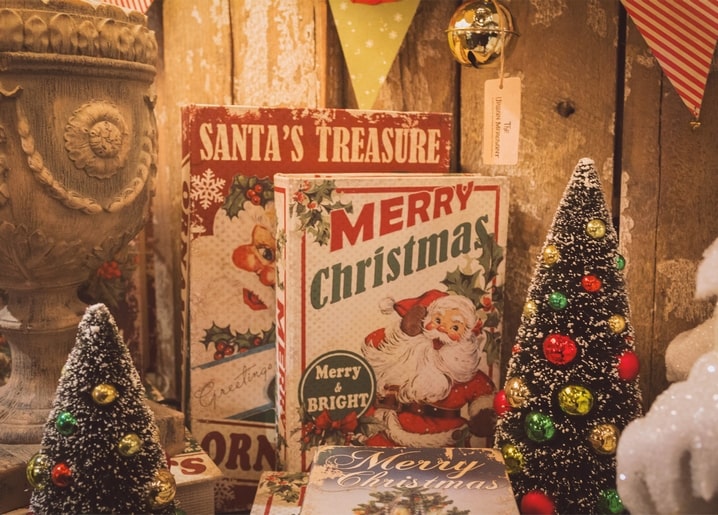 Vintage-Weihnachtskarten mit Weihnachtsmann vor Holzwand zwischen schneebedeckten Bäumchen
