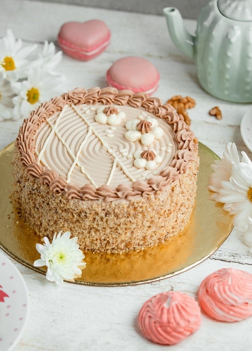 Walnut crumb cake with pink macarons, daisies and a mint-green teapot