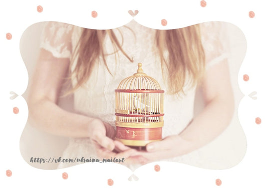 Young woman in a white lace dress holding a small birdcage with a white bird