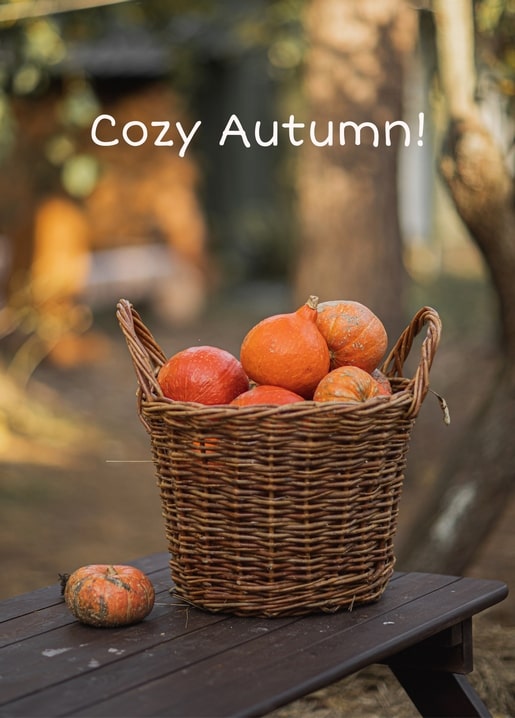 Woven wicker basket filled with orange pumpkins and squash on a rustic wooden table.