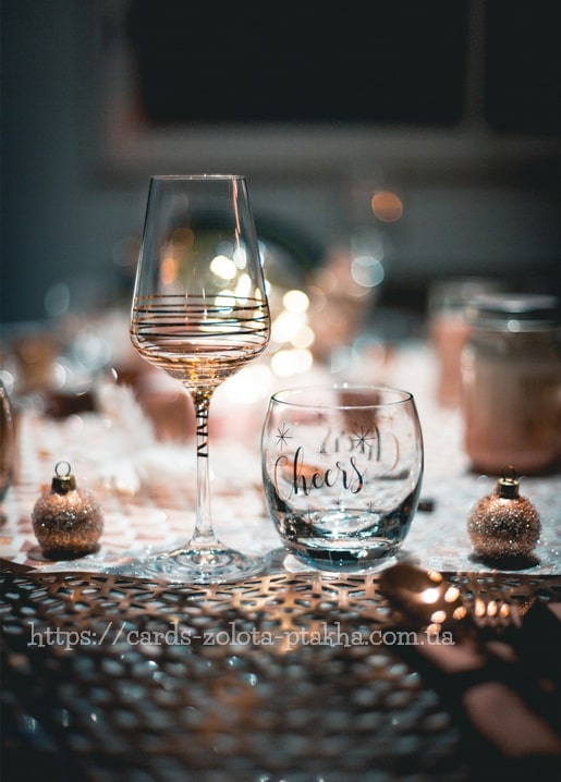 Weinglas und Trinkglas mit Sternen auf einem festlichen Silvestertisch