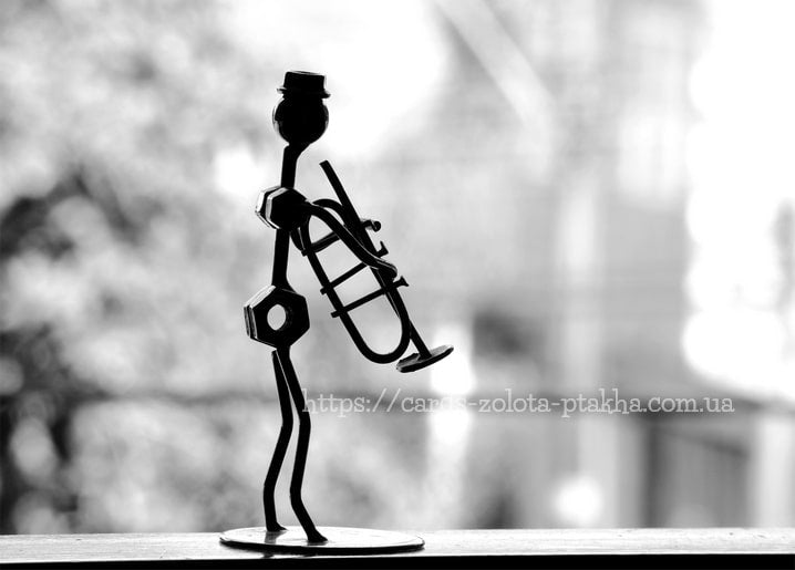 Silhouette einer Draht-Skulptur eines Trompeters mit Zylinder vor unscharfem Bokeh-Hintergrund