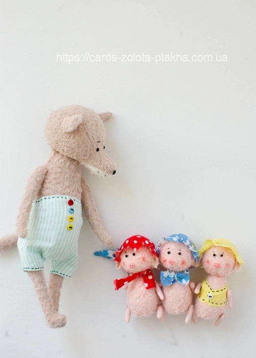 Plush wolf in striped overalls standing beside three felted piglets in bonnets