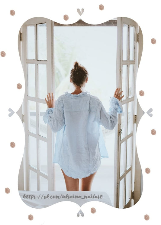Woman in a pale blue linen shirt opening white French doors to bright light