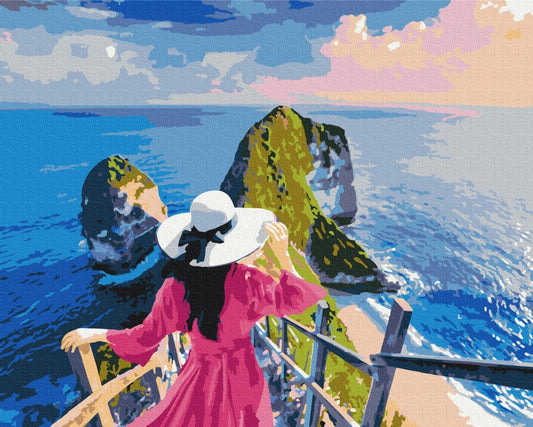Paint-by-number kit showing a woman in a pink dress overlooking sea rock stacks