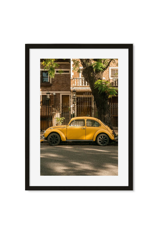 Yellow Volkswagen Beetle parked on a tree-lined European street
